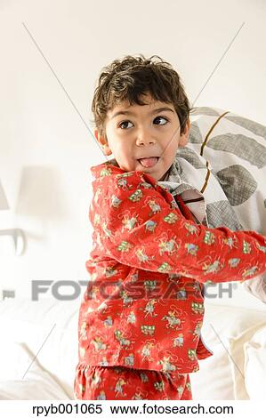 Stock Photography - Kid playing on bed in a pijama. Fotosearch