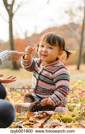 Kid playing with her mother at the park View Large Photo Image Stock Image - Kid playing with her mother at the park. Fotosearch