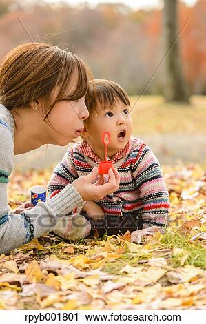 Kid playing with her mother at the park View Large Photo Image Stock Image - Kid playing with her mother at the park. Fotosearch