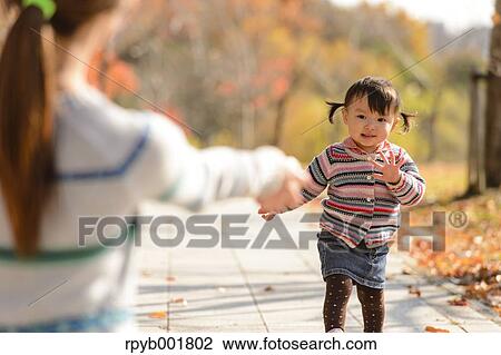 Kid playing with her mother at the park View Large Photo Image Stock Image - Kid playing with her mother at the park. Fotosearch