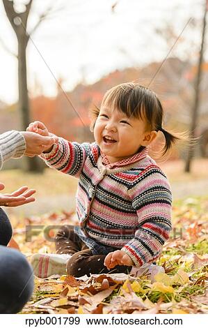 Kid playing with her mother at the park View Large Photo Image Stock Photo - Kid playing with her mother at the park. Fotosearch