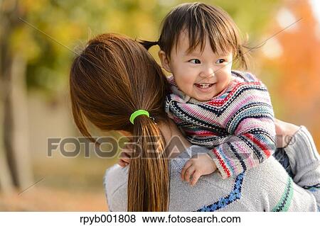 Stock Photo - Kid playing with her mother at the park. Fotosearch