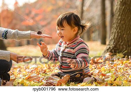 Stock Photograph - Kid playing with her mother at the park. Fotosearch
