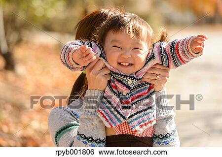 Stock Photograph - Kid playing with her mother at the park. Fotosearch