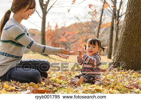Stock Photography - Kid playing with her mother at the park. Fotosearch