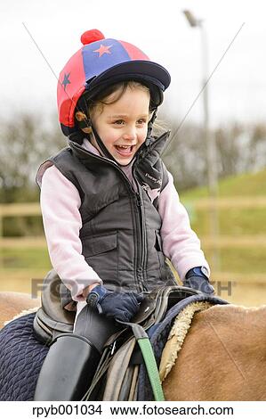 Kid riding on a horse View Large Photo Image Picture - Kid riding on a horse. Fotosearch