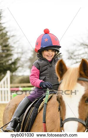 Kid riding on a horse View Large Photo Image Stock Image - Kid riding on a horse. Fotosearch