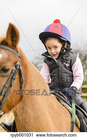 Kid riding on a horse View Large Photo Image Stock Image - Kid riding on a horse. Fotosearch
