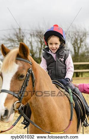 Kid riding on a horse View Large Photo Image Stock Image - Kid riding on a horse. Fotosearch