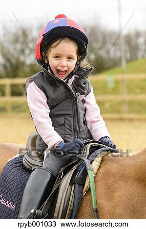 Kid riding on a horse View Large Photo Image Stock Image - Kid riding on a horse. Fotosearch