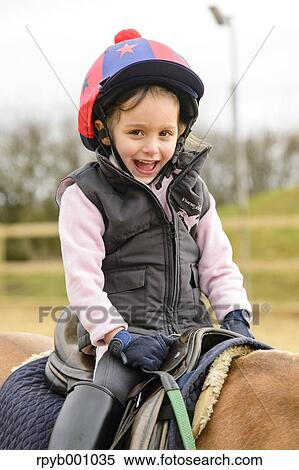 Kid riding on a horse View Large Photo Image Stock Photography - Kid riding on a horse. Fotosearch