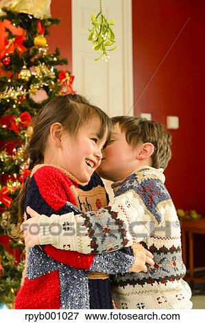Kids kissing in the house at Christmas View Large Photo Image Stock Photo - Kids kissing in the house at Christmas. Fotosearch