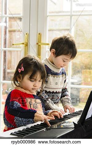 Kids playing piano View Large Photo Image Stock Photograph - Kids playing piano. Fotosearch