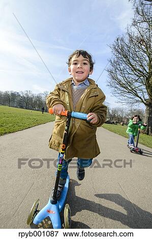 Stock Photo - Kids playing with kickboards in a park. Fotosearch
