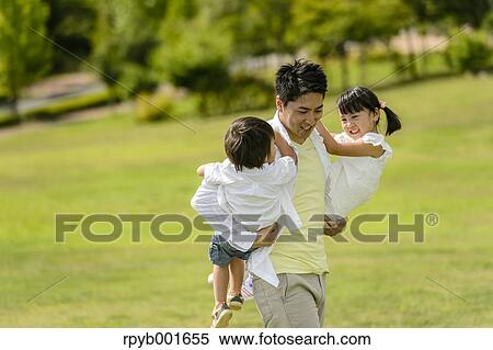 Stock Photography - Kids with dad at the park. Fotosearch