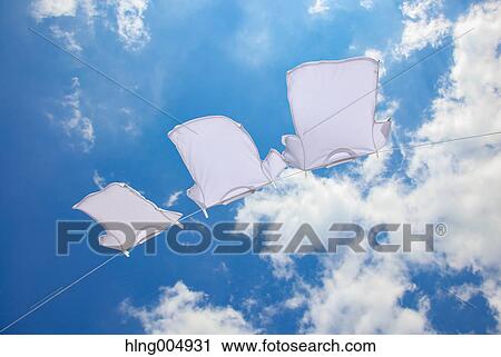 Stock Image - Laundry hanging against blue sky. Fotosearch