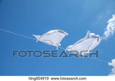 Laundry hanging against blue sky View Large Photo Image Stock Photo - Laundry hanging against blue sky. Fotosearch
