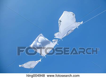 Laundry hanging against blue sky View Large Photo Image Stock Photo - Laundry hanging against blue sky. Fotosearch