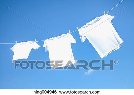 Laundry hanging against blue sky View Large Photo Image Stock Photograph - Laundry hanging against blue sky. Fotosearch