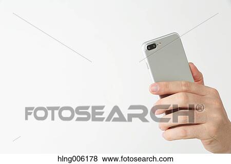 Male hand holding new type of smartphone View Large Photo Image Stock Photo - Male hand holding new type of smartphone. Fotosearch