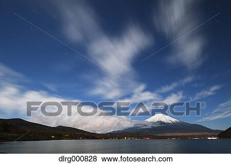 Stock Photo - Night view of cloudy sky and Mount Fuji at night from Lake Yamanaka, Yamanashi Prefecture, Japan. Fotosearch