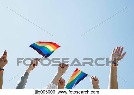 Stock Photograph - People with rainbow flags. Fotosearch