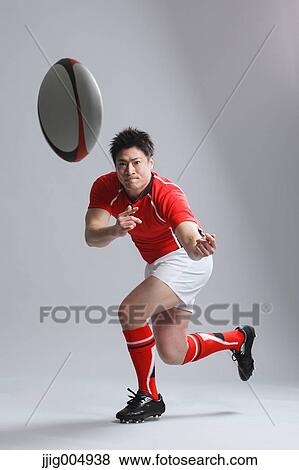 Stock Photo - Portrait of Japanese rugby player throwing ball. Fotosearch