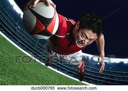 Stock Photography - Portrait of Japanese rugby player diving to score a try. Fotosearch