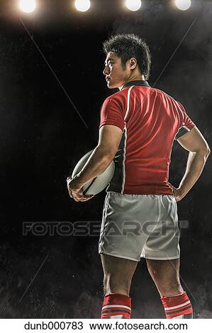 Stock Image - Portrait of Japanese rugby player with ball. Fotosearch