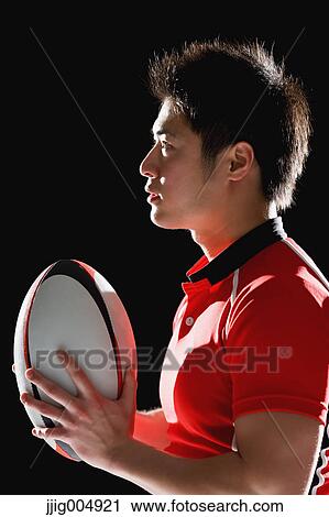 Stock Image - Portrait of Japanese rugby player with ball. Fotosearch