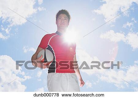 Stock Photo - Portrait of Japanese rugby player with ball. Fotosearch