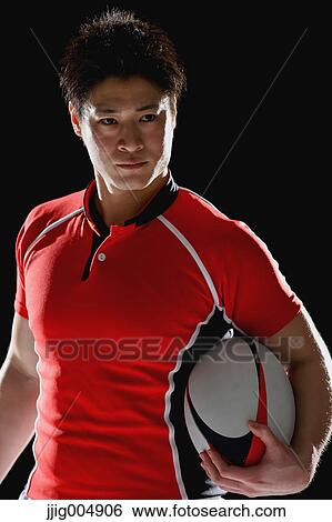 Stock Photograph - Portrait of Japanese rugby player with ball. Fotosearch