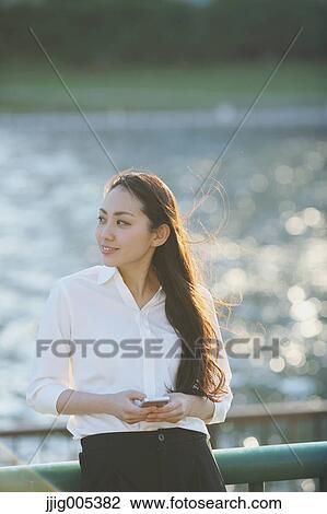 Portrait of young Japanese businesswoman by a river downtown Tokyo View Large Photo Image Stock Image - Portrait of young Japanese businesswoman by a river downtown Tokyo. Fotosearch