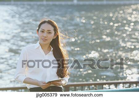 Portrait of young Japanese businesswoman by a river downtown Tokyo View Large Photo Image Stock Photo - Portrait of young Japanese businesswoman by a river downtown Tokyo. Fotosearch