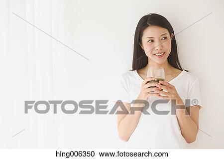 Stock Image - Portrait of young Japanese woman in a white room. Fotosearch