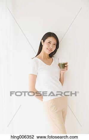 Stock Image - Portrait of young Japanese woman in a white room. Fotosearch
