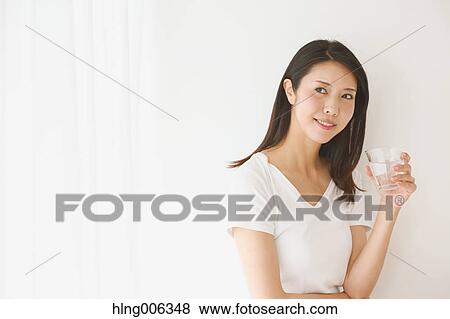 Stock Photo - Portrait of young Japanese woman in a white room. Fotosearch