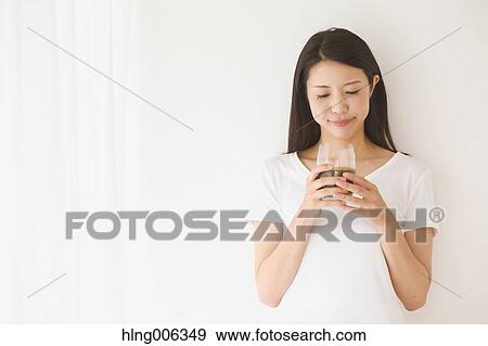 Stock Photo - Portrait of young Japanese woman in a white room. Fotosearch