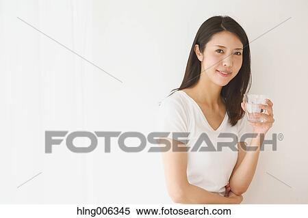 Stock Photography - Portrait of young Japanese woman in a white room. Fotosearch