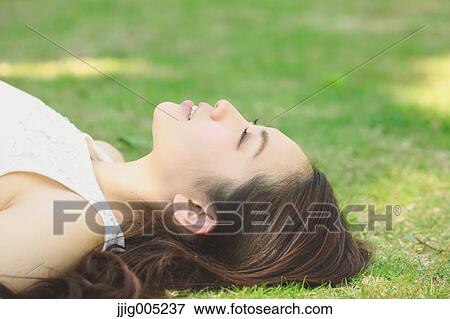 Portrait of young Japanese woman laying on green grass View Large Photo Image Stock Photo - Portrait of young Japanese woman laying on green grass. Fotosearch
