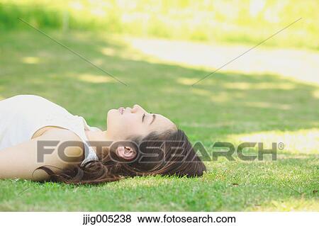 Portrait of young Japanese woman laying on green grass View Large Photo Image Stock Photo - Portrait of young Japanese woman laying on green grass. Fotosearch