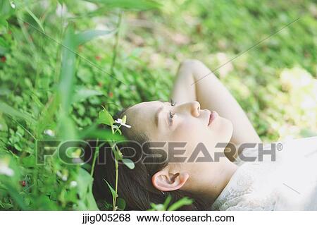Portrait of young Japanese woman laying on green grass View Large Photo Image Stock Photo - Portrait of young Japanese woman laying on green grass. Fotosearch