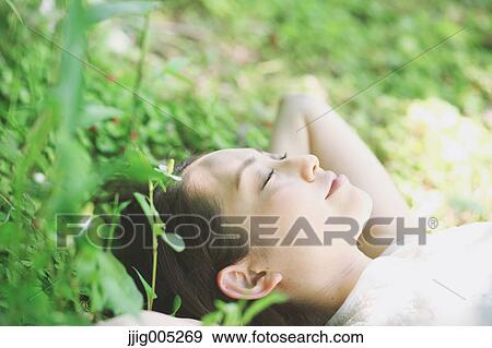 Portrait of young Japanese woman laying on green grass View Large Photo Image Stock Photo - Portrait of young Japanese woman laying on green grass. Fotosearch