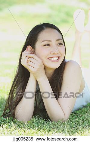 Portrait of young Japanese woman laying on green grass View Large Photo Image Stock Photography - Portrait of young Japanese woman laying on green grass. Fotosearch