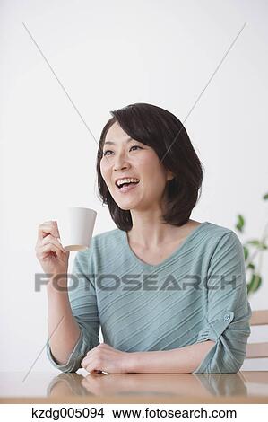 Senior Japanese woman having coffee in the living room View Large Photo Image Picture - Senior Japanese woman having coffee in the living room. Fotosearch