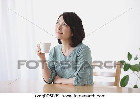 Senior Japanese woman having coffee in the living room View Large Photo Image Stock Photo - Senior Japanese woman having coffee in the living room. Fotosearch