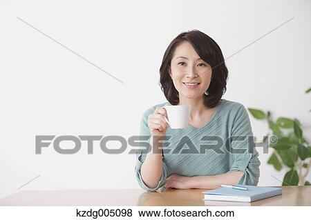 Senior Japanese woman having coffee in the living room View Large Photo Image Stock Photo - Senior Japanese woman having coffee in the living room. Fotosearch