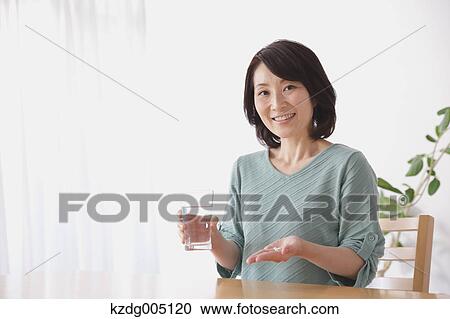 Senior Japanese woman taking pills in the living room View Large Photo Image Stock Image - Senior Japanese woman taking pills in the living room. Fotosearch