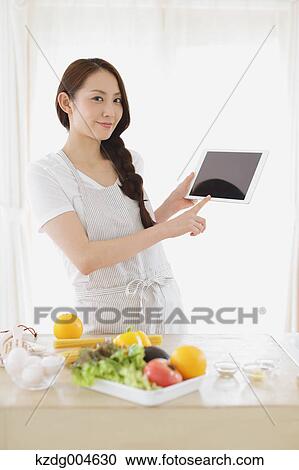 Young attractive Japanese woman cooking at home with tablet View Large Photo Image Stock Image - Young attractive Japanese woman cooking at home with tablet. Fotosearch