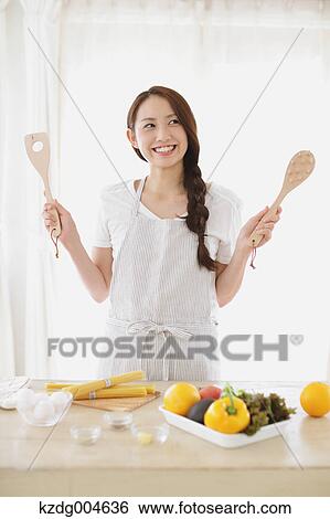 Young attractive Japanese woman cooking at home View Large Photo Image Stock Photograph - Young attractive Japanese woman cooking at home. Fotosearch